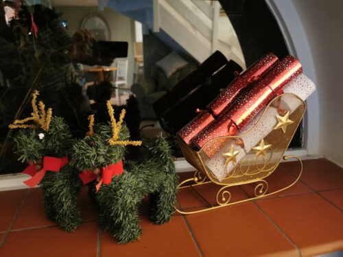 The kitchen windowsill with a golden sleigh and crackers.